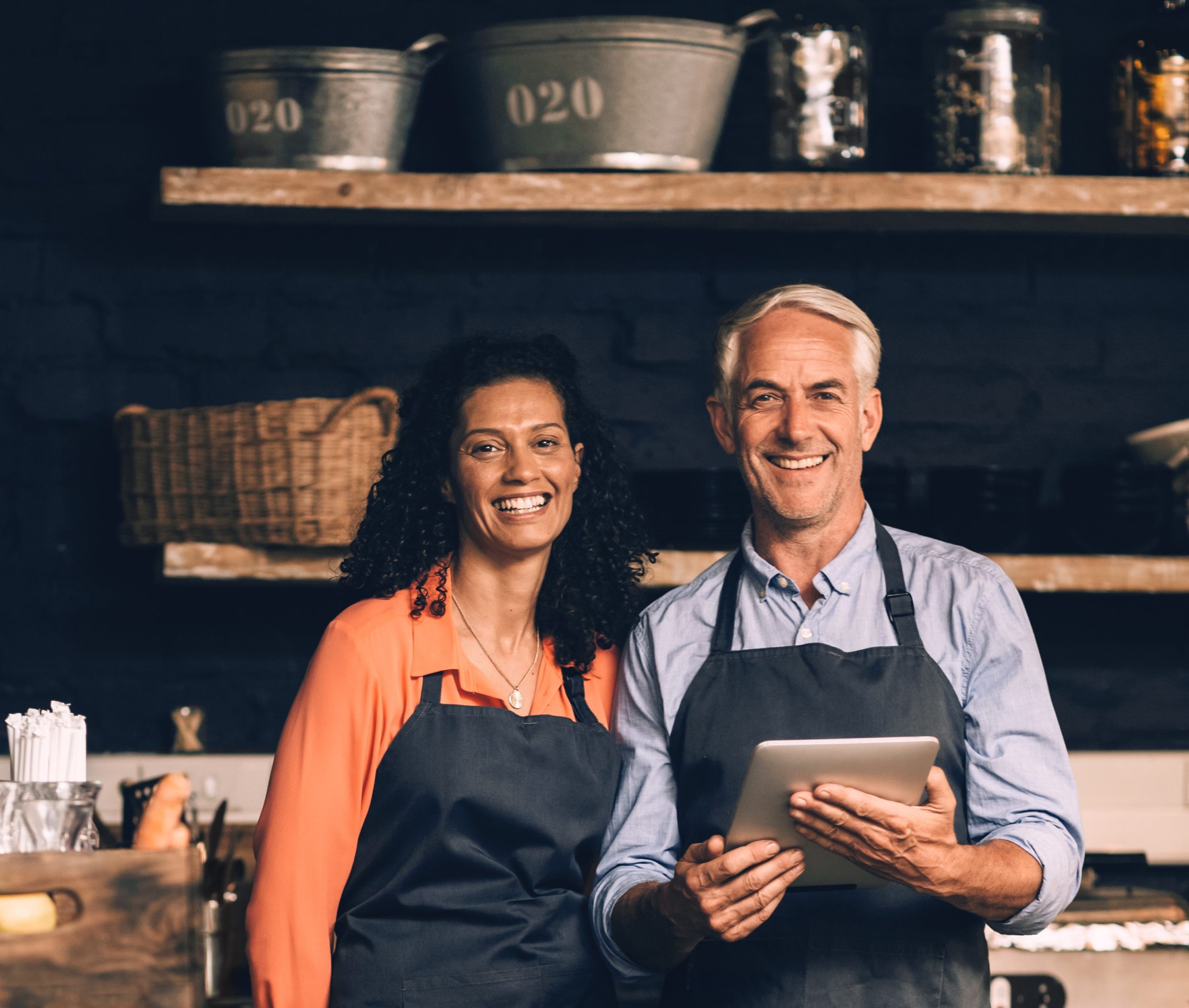 Mature couple smiling while using a tablet together