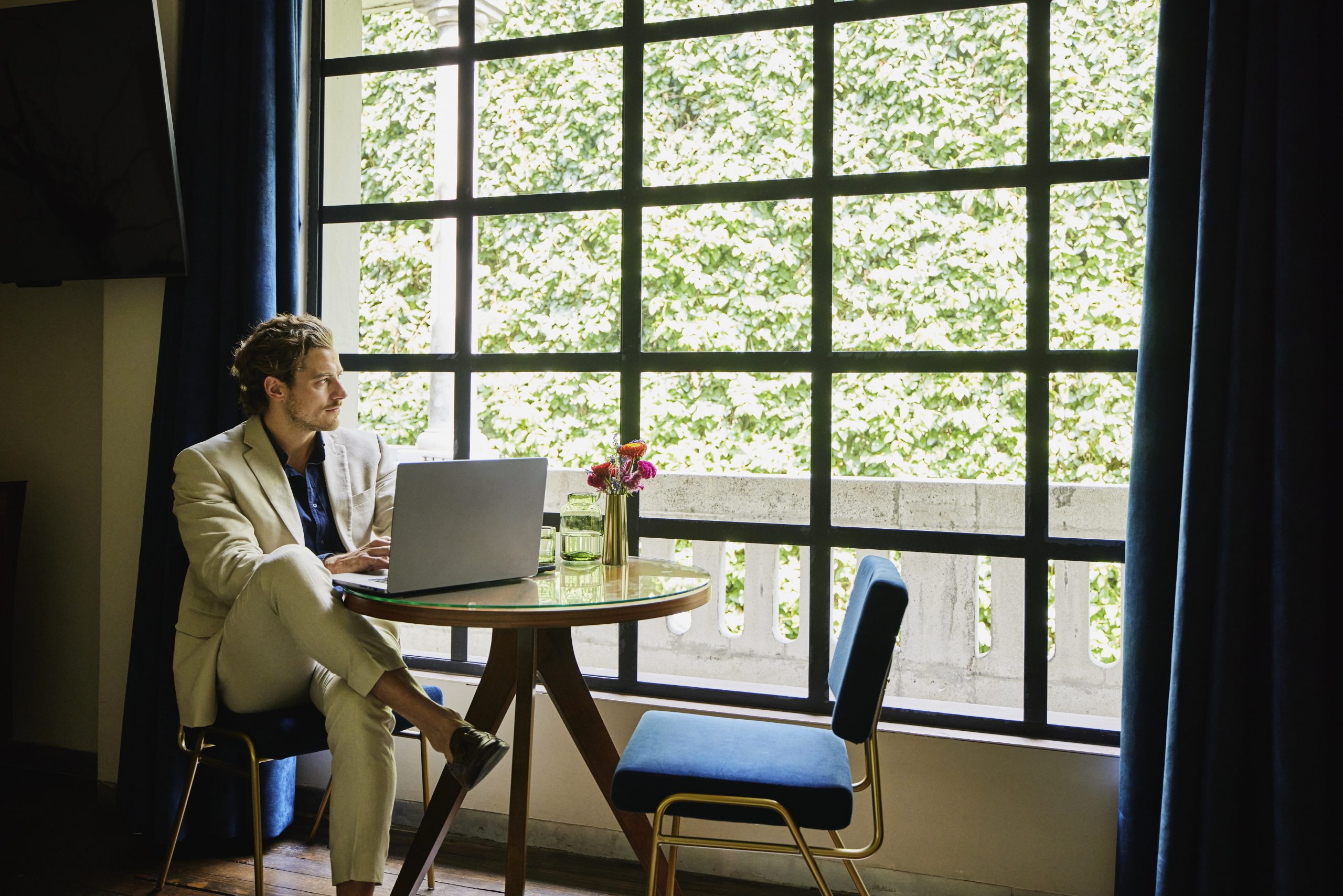 Man with laptop sitting by window